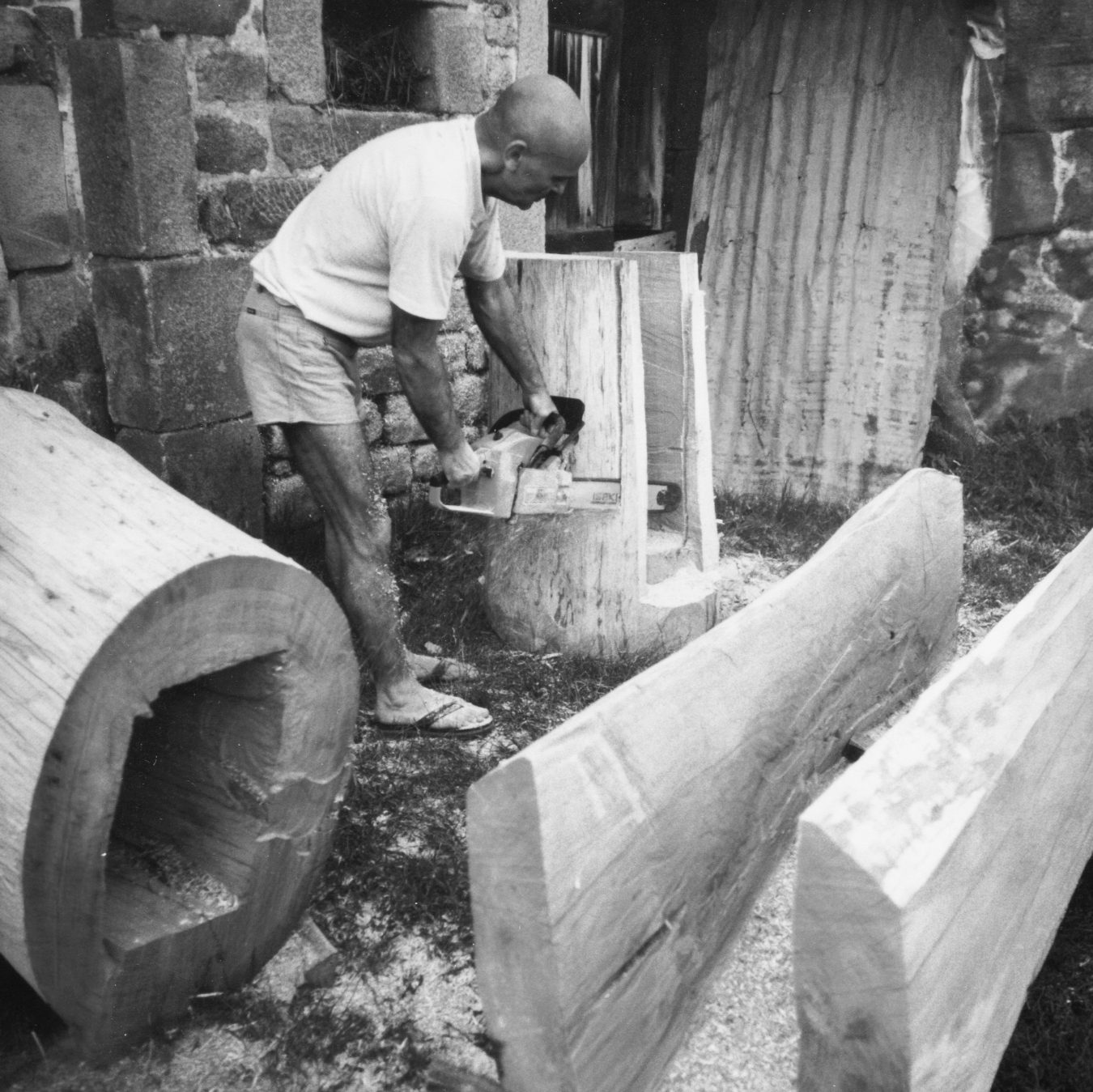 George Apostu lucrând cu drujba un trunchi de lemn, Orluc, Limousin, Franța, 1986